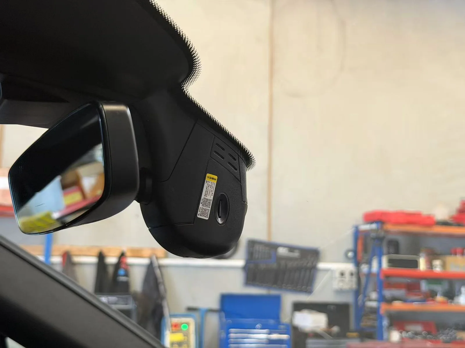 Mirror-style dash cam mounted at the headliner edge of a Porsche Cayenne