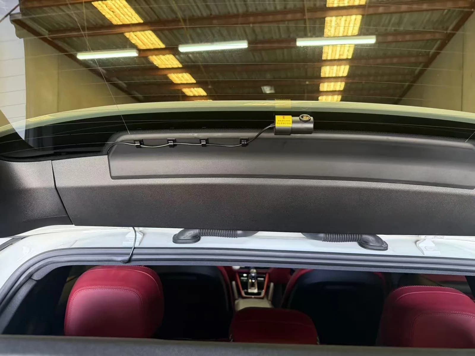 Rear dash cam mounted at the top of the rear windscreen on a Porsche Cayenne