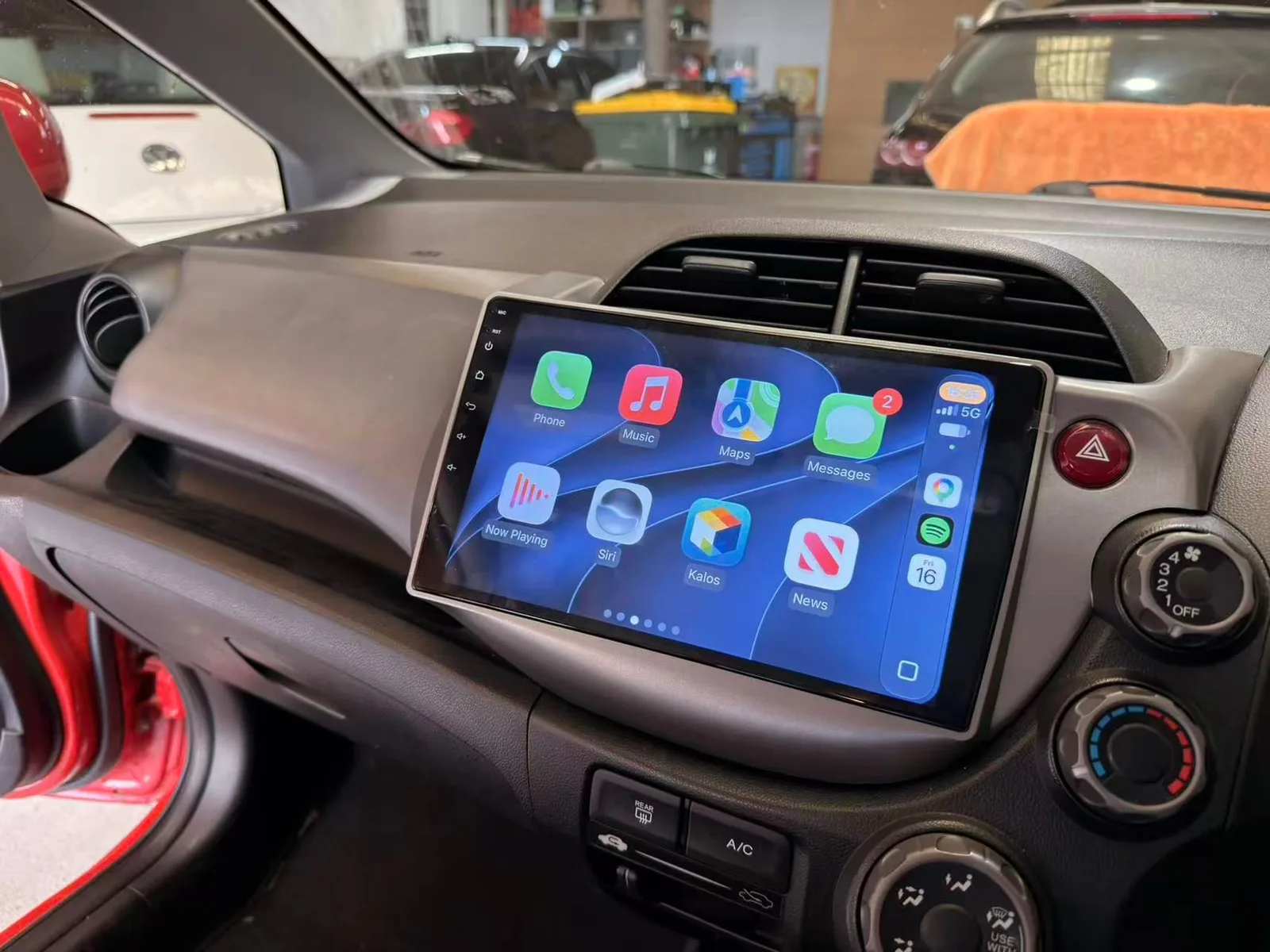 Apple CarPlay home screen on a touchscreen head unit in the factory position of a 2010 Honda Jazz