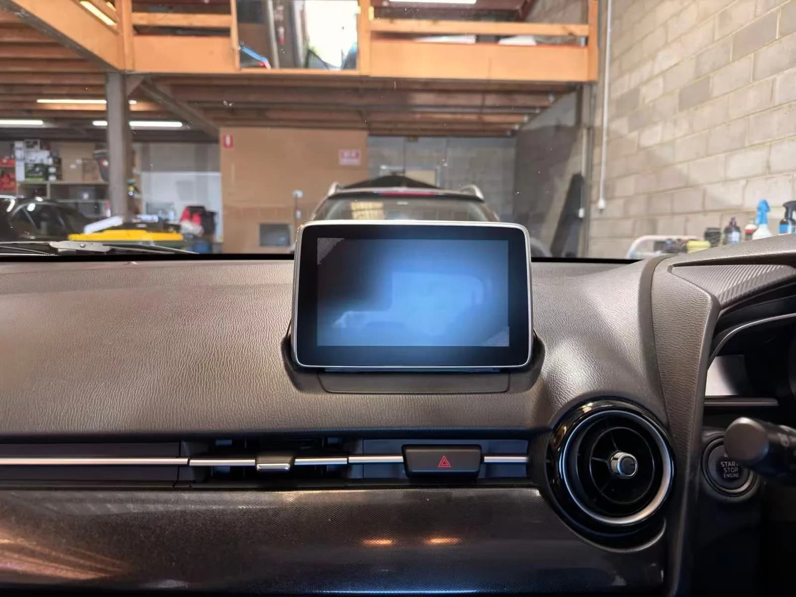 The factory Mazda Connect screen on the dash of a 2015 Mazda2 before the upgrade