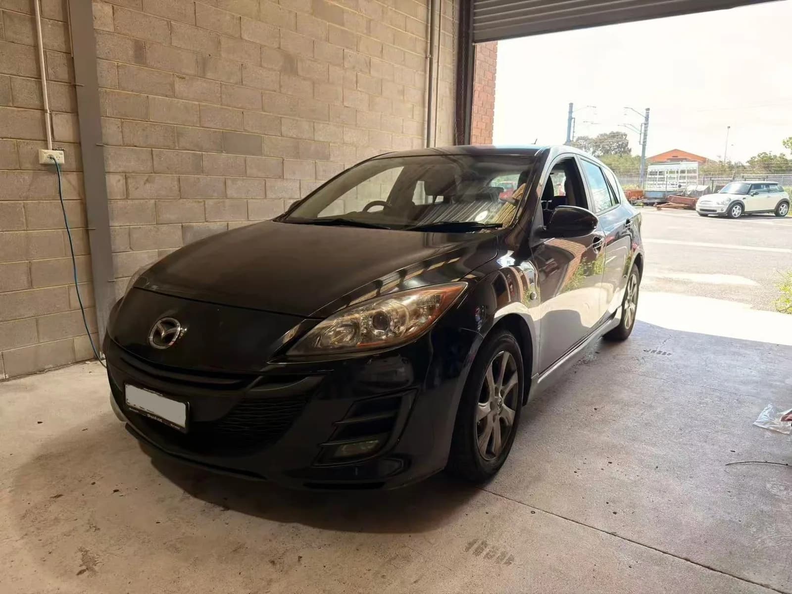 Black 2010 Mazda3 hatch at the C1 Automotive workshop in Oakleigh South, number plate redacted