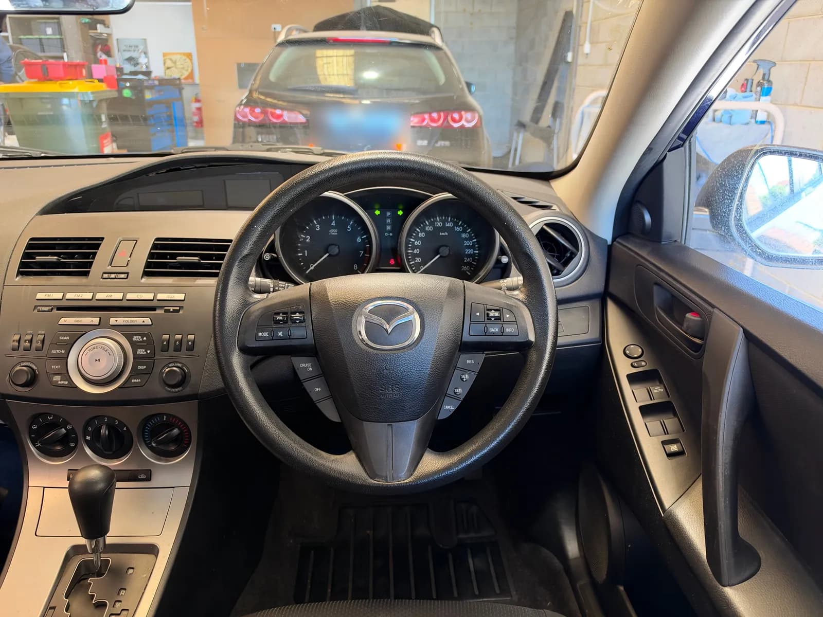 The dash of a 2011 Mazda3 before the upgrade, with the factory radio and no screen