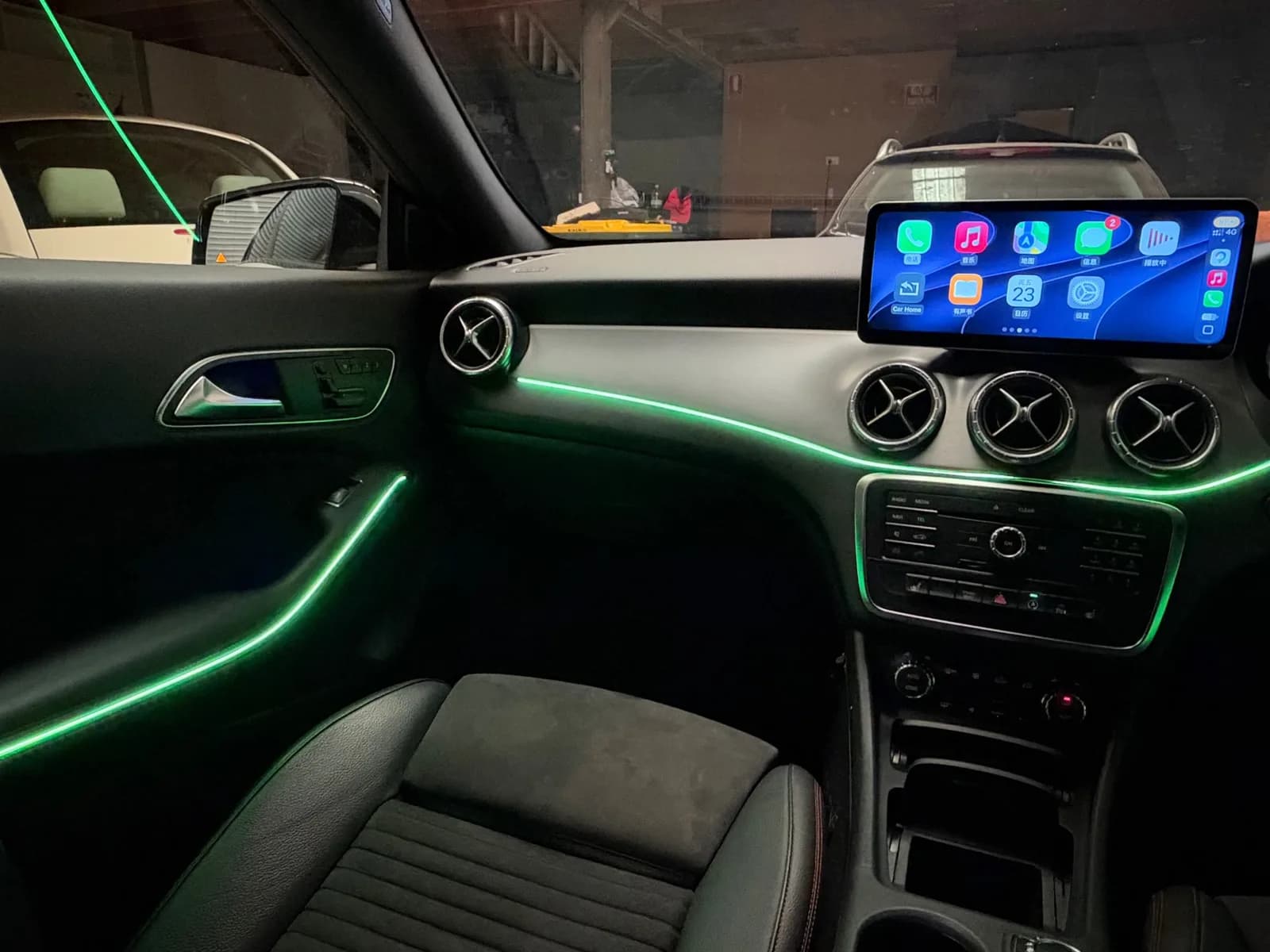 Green ambient lighting in a 2015 Mercedes-Benz CLA, with Apple CarPlay on the 12.3-inch screen