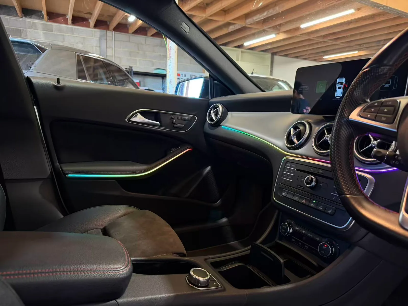 Colour-changing ambient lighting along the passenger door and dash trim of a 2015 Mercedes-Benz CLA